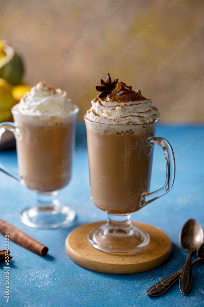 Latte with cinnamon in glass cup with cream. on blue background. Autumn comfort, warming drink. Mood lifestyle drink photo. Latte with cinnamon in glass cup with cream. on blue background. Autumn comfort, warming drink. Mood lifestyle drink photo.