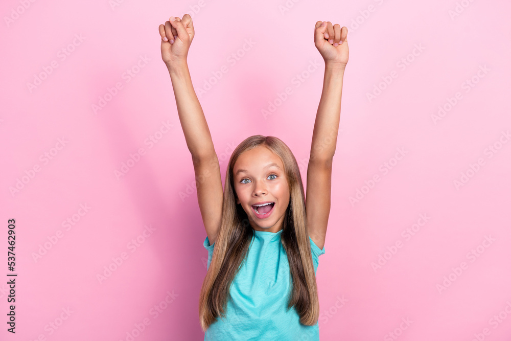 Photo of adorable lucky little child dressed teal t-shirt rising fists screaming isolated pink color background Photo of adorable lucky little child dressed teal t-shirt rising fists screaming isolated pink color background