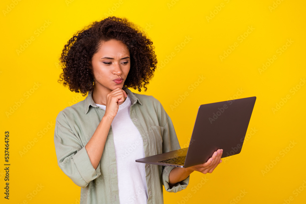 Photo of smart young brunette lady look laptop wear grey shirt isolated on yellow color background