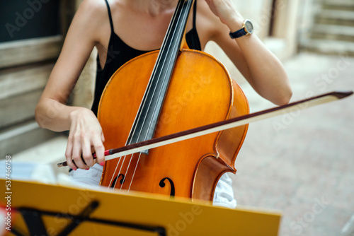 Happy young female musician playing the cello