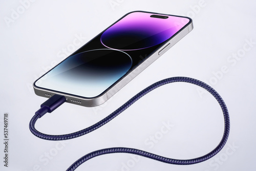 Принти на полотні a new smartphone is charging and flying in the air with a wire connected