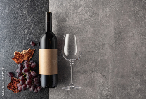 Red wine with grapes on a stone background.