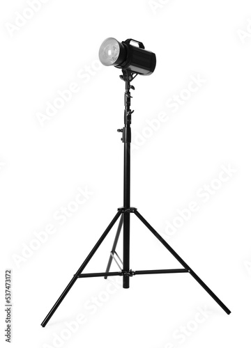 Studio flash light on tripod against white background. Professional photographer's equipment