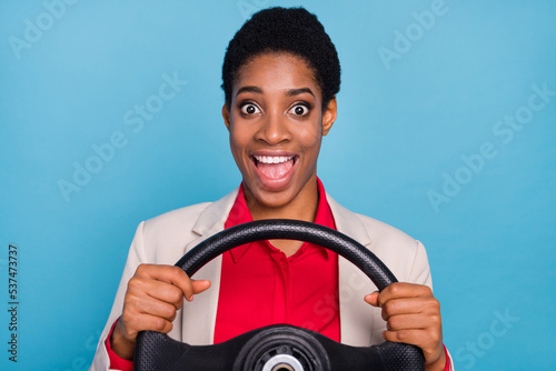 Portrait of astonished excited person hold wheel open mouth isolated on blue color background