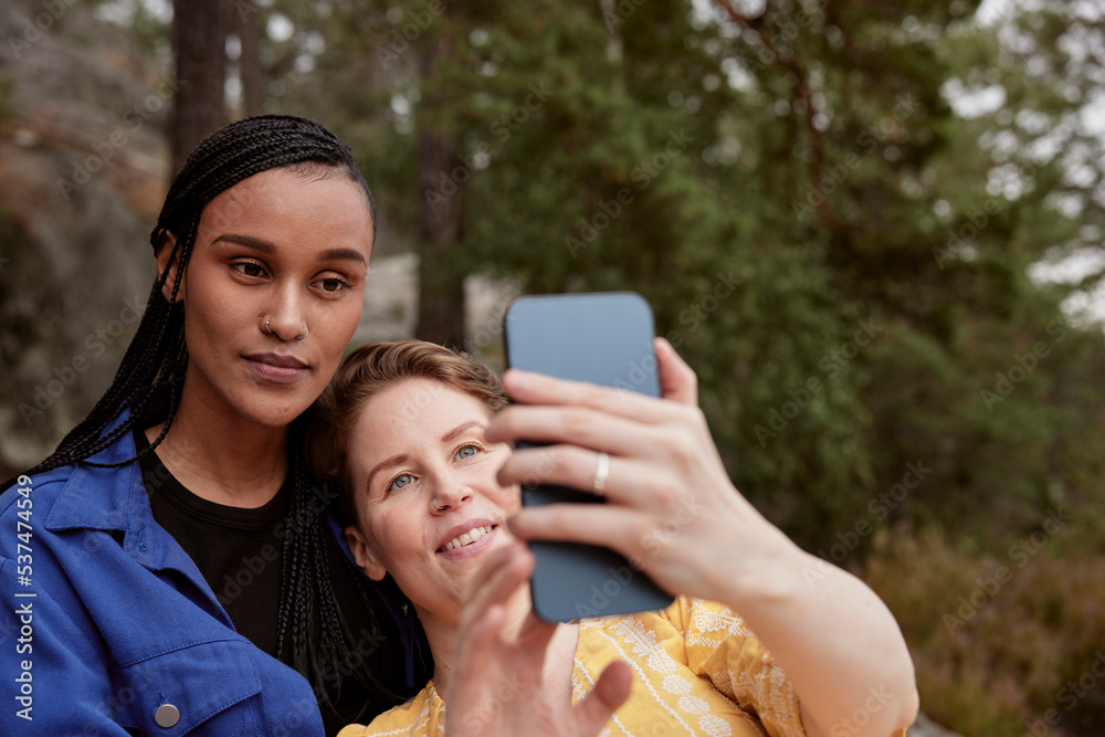 Female couple taking selfie outdoors Female couple taking selfie outdoors