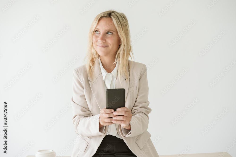 Businesswoman using mobile phone looking away Businesswoman using mobile phone looking away