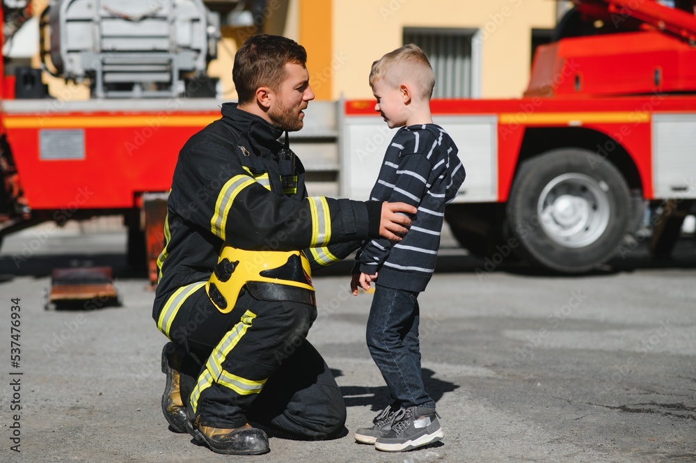 Firefighter holding child boy to save him in fire and smoke,Firemen rescue the boys from fire Firefighter holding child boy to save him in fire and smoke,Firemen rescue the boys from fire