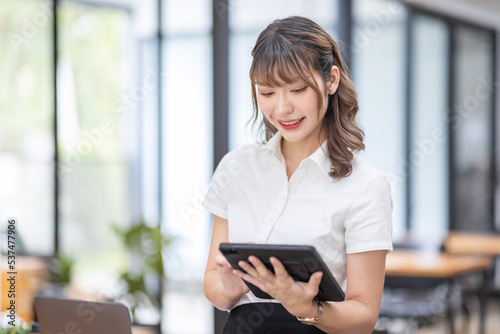 Smiling Happy Asian businessman working whith tablet in an workplace, accounting, statistics, and analytical research concept.
