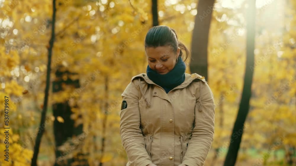 Cheerful girl collects fallen autumn leaves and throws Cheerful girl collects fallen autumn leaves and throws