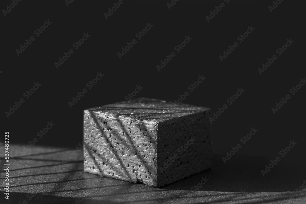 Black square geometric platform in sunlight with shadows. Concept of 3d podium for presentations of packaging and cosmetics. Close-up, copy space, monochrome image Black square geometric platform in sunlight with shadows. Concept of 3d podium for presentations of packaging and cosmetics. Close-up, copy space, monochrome image
