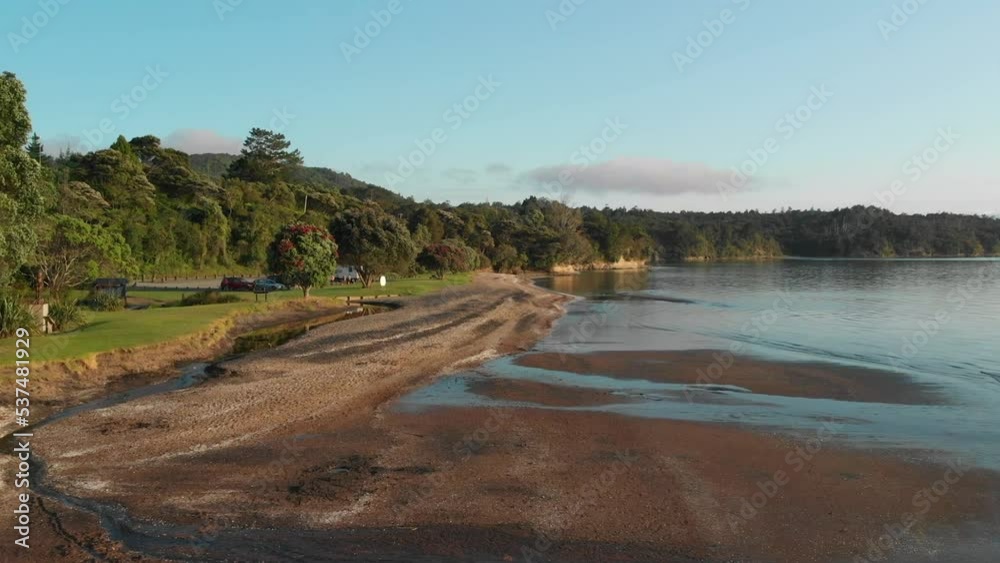 Cornwallis Beach in Auckland, New Zealand, slow low straight aerial drone view Cornwallis Beach in Auckland, New Zealand, slow low straight aerial drone view