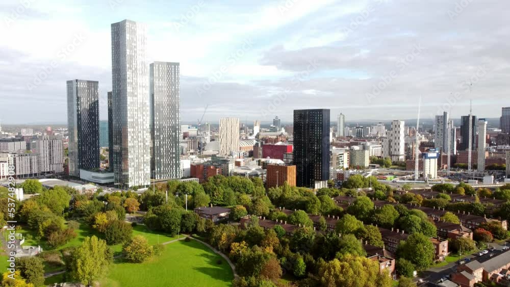 Manchester city parkland aerial view rising above trees to view modern high rise skyline Manchester city parkland aerial view rising above trees to view modern high rise skyline