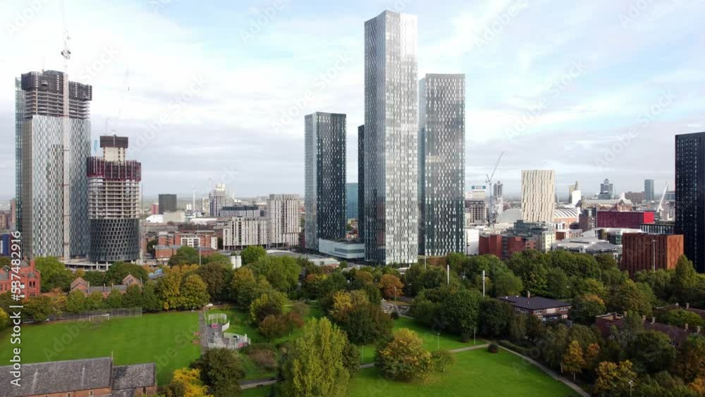 Manchester city Hulme parkland aerial view flying above trees to view modern high rise skyline Manchester city Hulme parkland aerial view flying above trees to view modern high rise skyline
