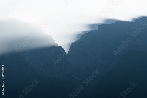 Stimmungsvolles Licht mit Lichtstrahlen und Reflektionen in den Bergen am Gardasee - Die Sonne beginnt den Nebel zu durchbrechen