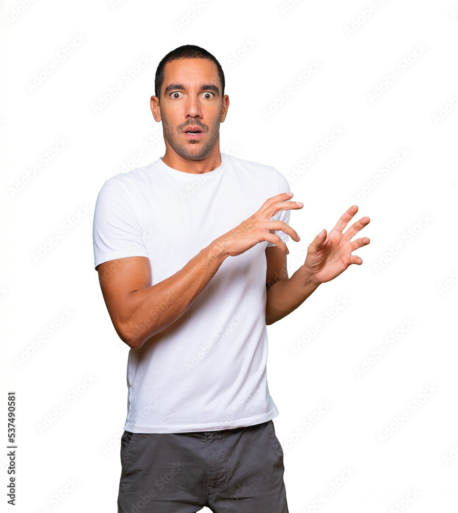 Scared young man screaming against background