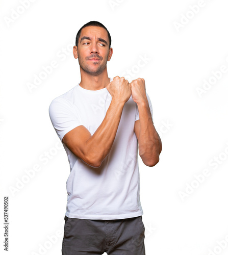 Serious young man making a gesture of strength