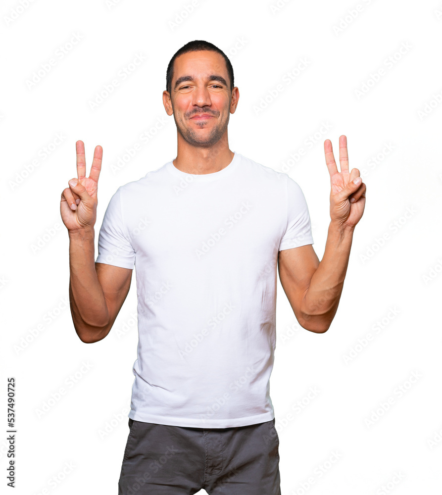 Happy young man making a victory gesture with his fingers Happy young man making a victory gesture with his fingers