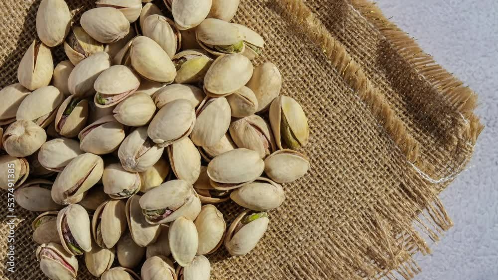 4k zoom in out Pistachios in burlap sack on concrete table. Organic pistachios. Vegan Healthy