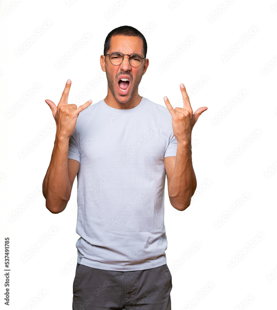 Fototapeta premium Naughty young man making a rock gesture