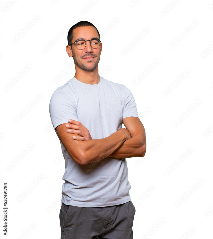 Fototapeta premium Satisfied young man with crossed arms gesture