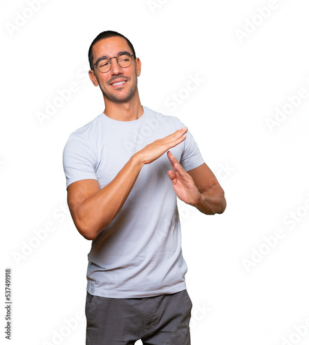 Friendly young man making a time out gesture with his hands © agongallud
