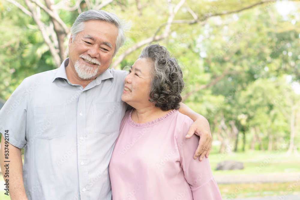 elderly healthy asian couple smile and relax in the park together elderly healthy asian couple smile and relax in the park together