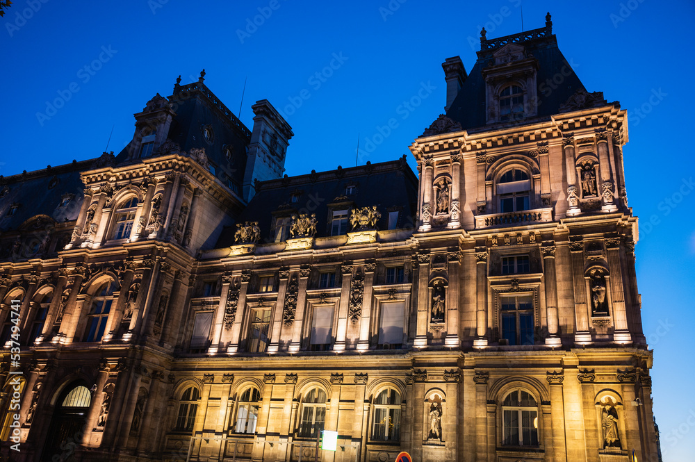 Obraz premium Paris Tourism Office is in the north wing of the Hotel de Ville (City Hall) located in famous le Marais district, Paris, France. Night scene, lit up building