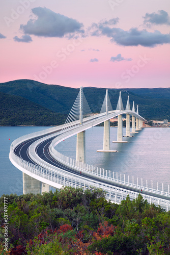 Fototapeta Naklejka Na Ścianę i Meble -  Peljesac Bridge, Croatia. Image of beautiful modern multi-span cable-stayed Peljesac Bridge over the sea in Dubrovnik-Neretva County, Croatia at sunrise.