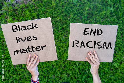 A person holding a black lives matter banner at a protest.