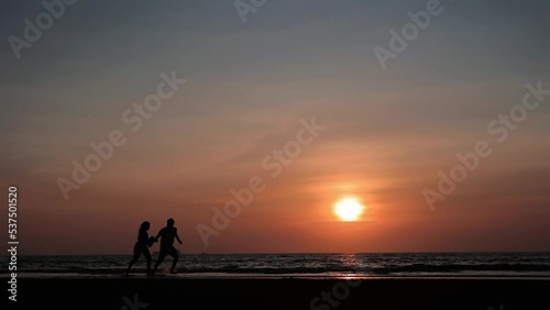 sunset at the beach in couple runing waves shore