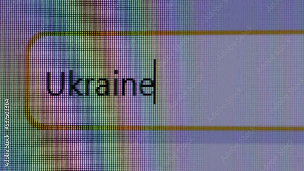 User enters text query for word Ukraine in search bar form of internet browser on computer. Macro pixels of monitor screen display. Political news. User presses Enter key on keyboard