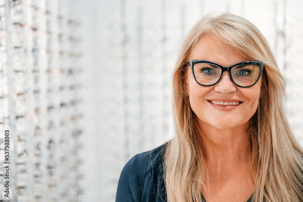 Looking at the camera. Woman in store trying new glasses Looking at the camera. Woman in store trying new glasses