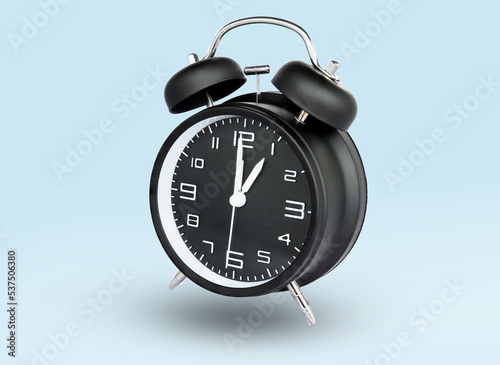 remote image of The black alarm clock is set to 1:00 a.m. a blue background.