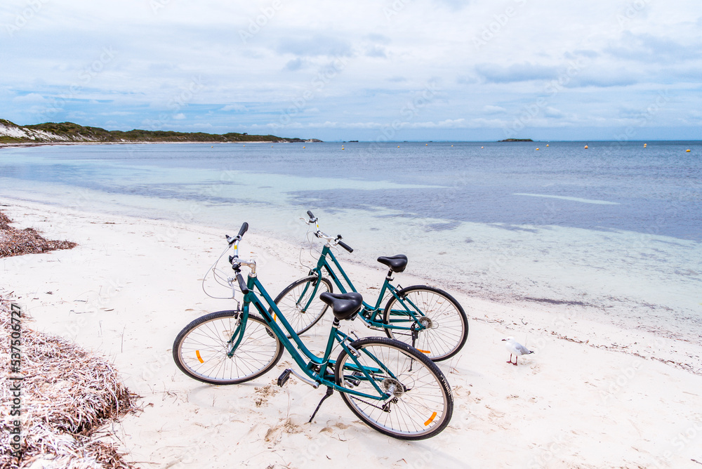 Fototapeta premium Two bicycles parked on a beach on Rottnest Island, Western Australia. Bike rental for tourists. Scenic view