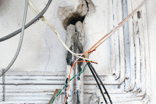 Hazard electrical wiring. Exposed wire in the electrical wiring in the wall. Selective focus