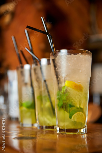 A set of Mojito cocktails with straws on the bar