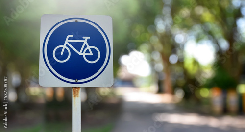 Bike path traffic sign on metal pole, soft and selective focus, blur mountain background.