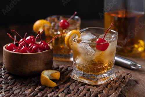 Old fashioned cocktail with orange peel and cherry photo