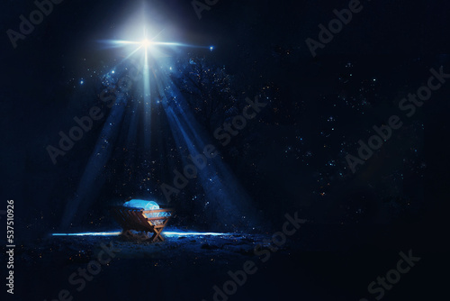 Nativity scene. Christian Christmas concept. Birth of Jesus Christ. Wooden manger in dark blue night. Banner, copy space. Jesus is reason for season. Salvation, Messiah, Emmanuel, God with us, hope