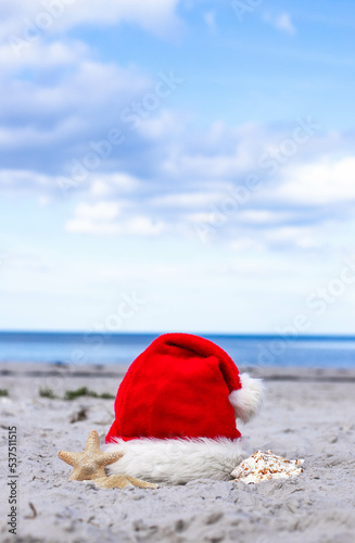 Christmas background Santa Claus hat on the beach with starfish