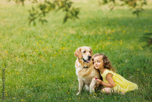 the relationship of a child with a golden retriever dog on the grass in the park