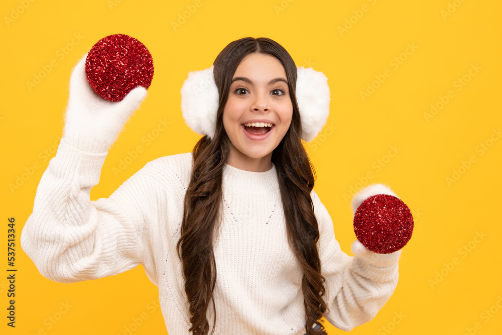 Teenager child santa girl in fur sweater, christmas ball isolated on yellow background. Happy New Year, celebration holiday concept. Teenager child santa girl in fur sweater, christmas ball isolated on yellow background. Happy New Year, celebration holiday concept.