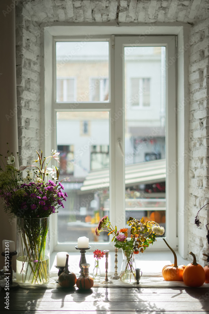 Variety of flowers in a vase on a wooden table in a vintage style room
