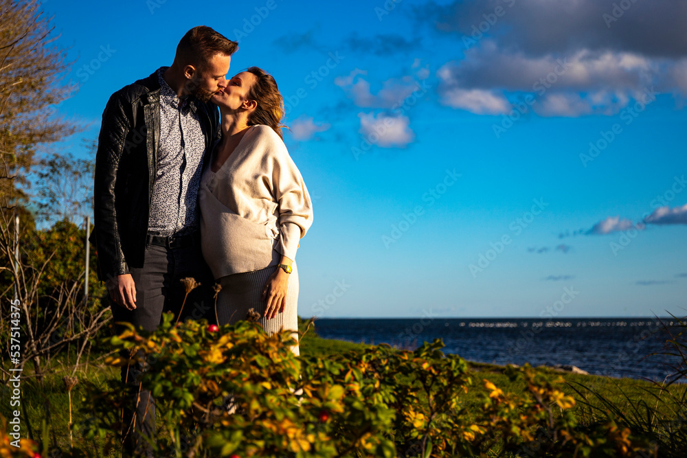 A handsome man tenderly embraces his pregnant wife and shows her love ...