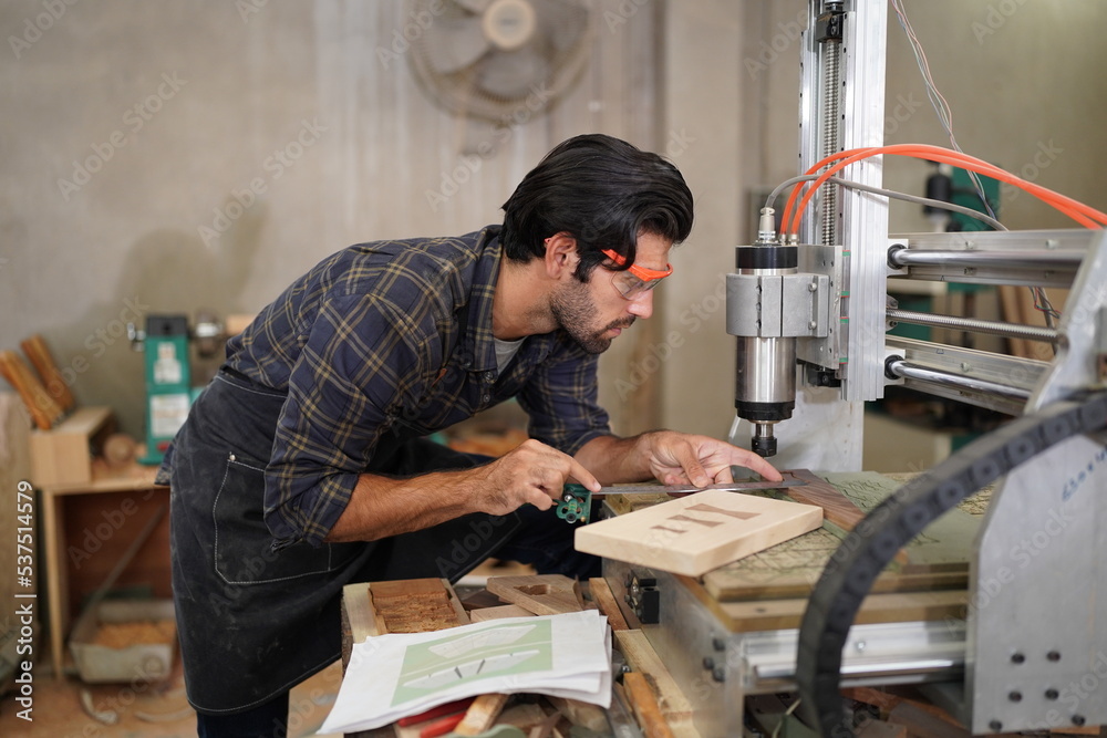 Contemporary Carpenter Working, Portrait of modern carpenter making wood furniture while working in joinery lit by sunlight with factory background on small business concept, copy space Contemporary Carpenter Working, Portrait of modern carpenter making wood furniture while working in joinery lit by sunlight with factory background on small business concept, copy space