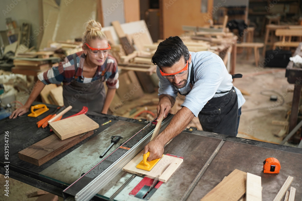 Contemporary Carpenter Working, Portrait of modern carpenter making wood furniture while working in joinery lit by sunlight with factory background on small business concept, copy space Contemporary Carpenter Working, Portrait of modern carpenter making wood furniture while working in joinery lit by sunlight with factory background on small business concept, copy space