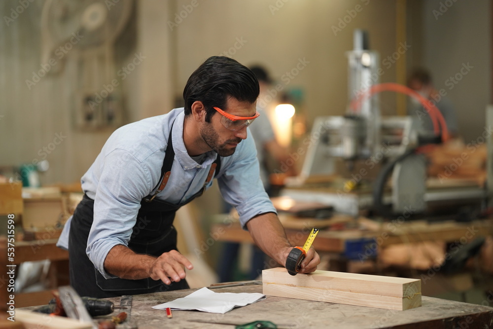 Contemporary Carpenter Working, Portrait of modern carpenter making wood furniture while working in joinery lit by sunlight with factory background on small business concept, copy space Contemporary Carpenter Working, Portrait of modern carpenter making wood furniture while working in joinery lit by sunlight with factory background on small business concept, copy space
