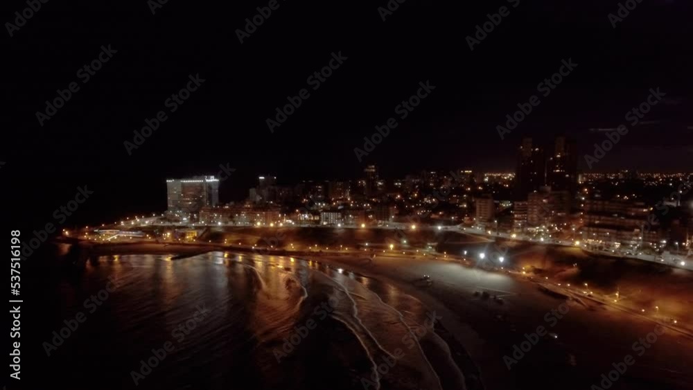 AERIAL - City lights and beach at night, Mar del Plata, Argentina, forward lowering AERIAL - City lights and beach at night, Mar del Plata, Argentina, forward lowering