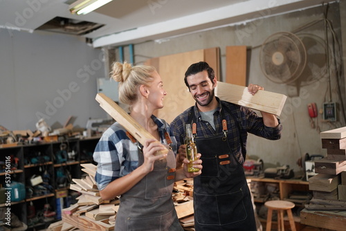 Happy Couple Carpenters have celeabate with a drink bottle after work of Assembling Furniture, Small business in wood DIY workplace office background
