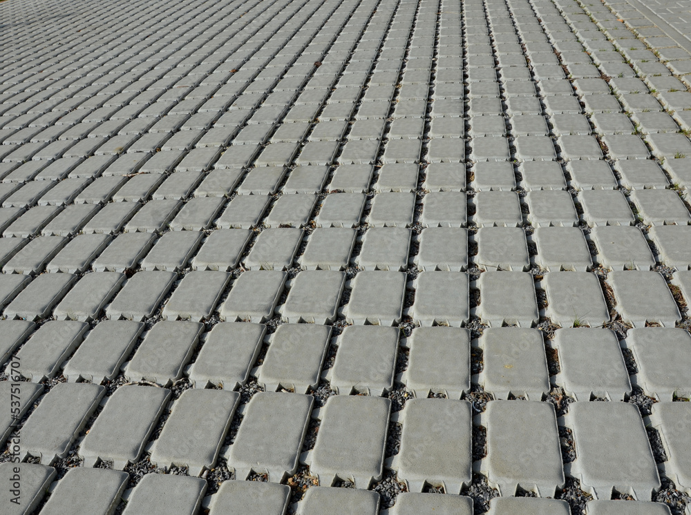Fototapeta premium absorbent porous paving absorbs a lot of rainwater in a city parking lot. border against vehicles on the shoulder at the entrance to the lawn. infiltration gaps with gravel.